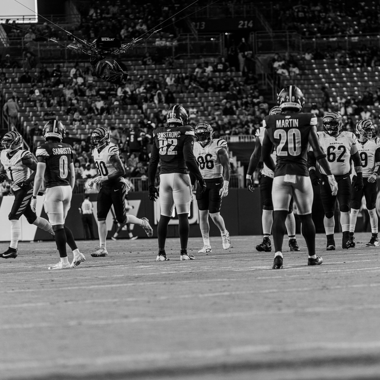Football players line up on the field during a professional game shown in black and white.