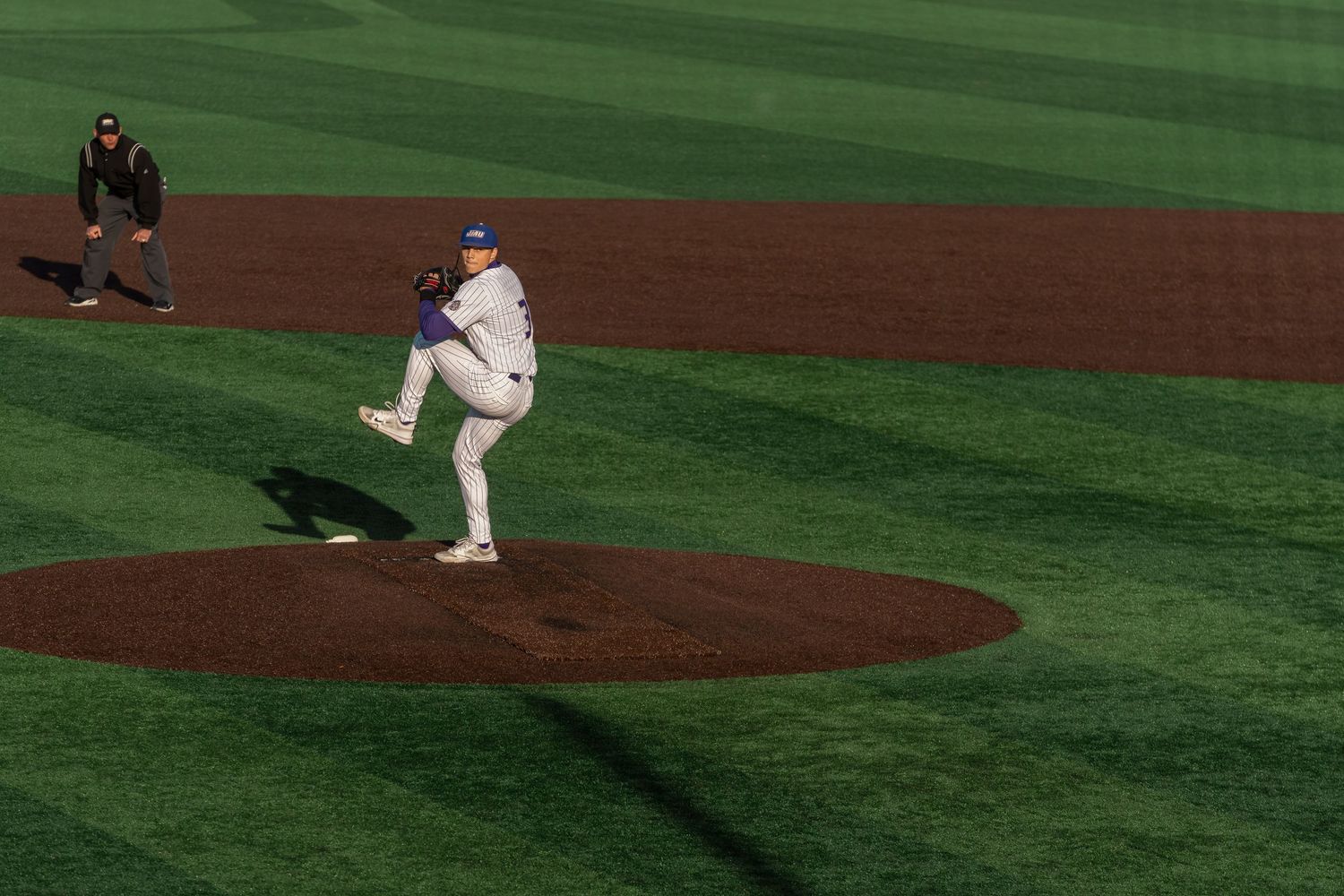 Baseball players positioned on a pristine green baseball field during a game or practice session.
