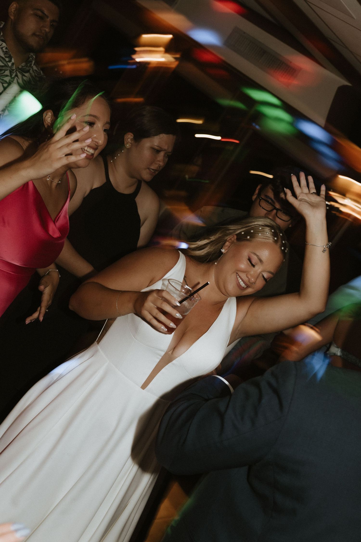 Wedding celebration dance party with colorful lights and motion blur effects.