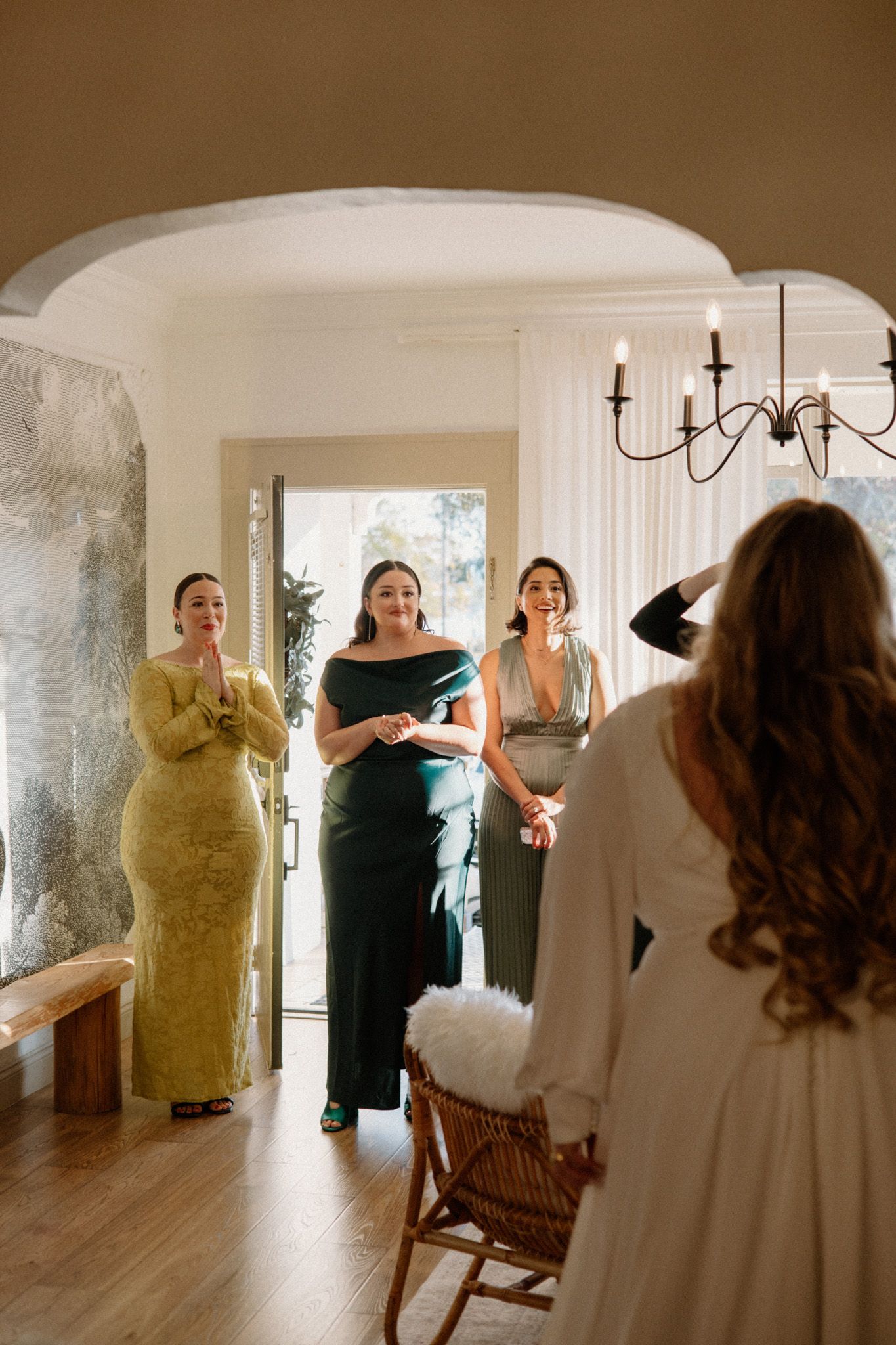 A bridal preparation scene in a bright, white room with wedding dresses on display.
