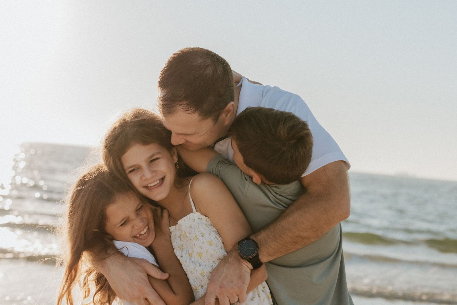 Loving couple embraces and shares intimate moments together during golden hour at a scenic beach setting.
