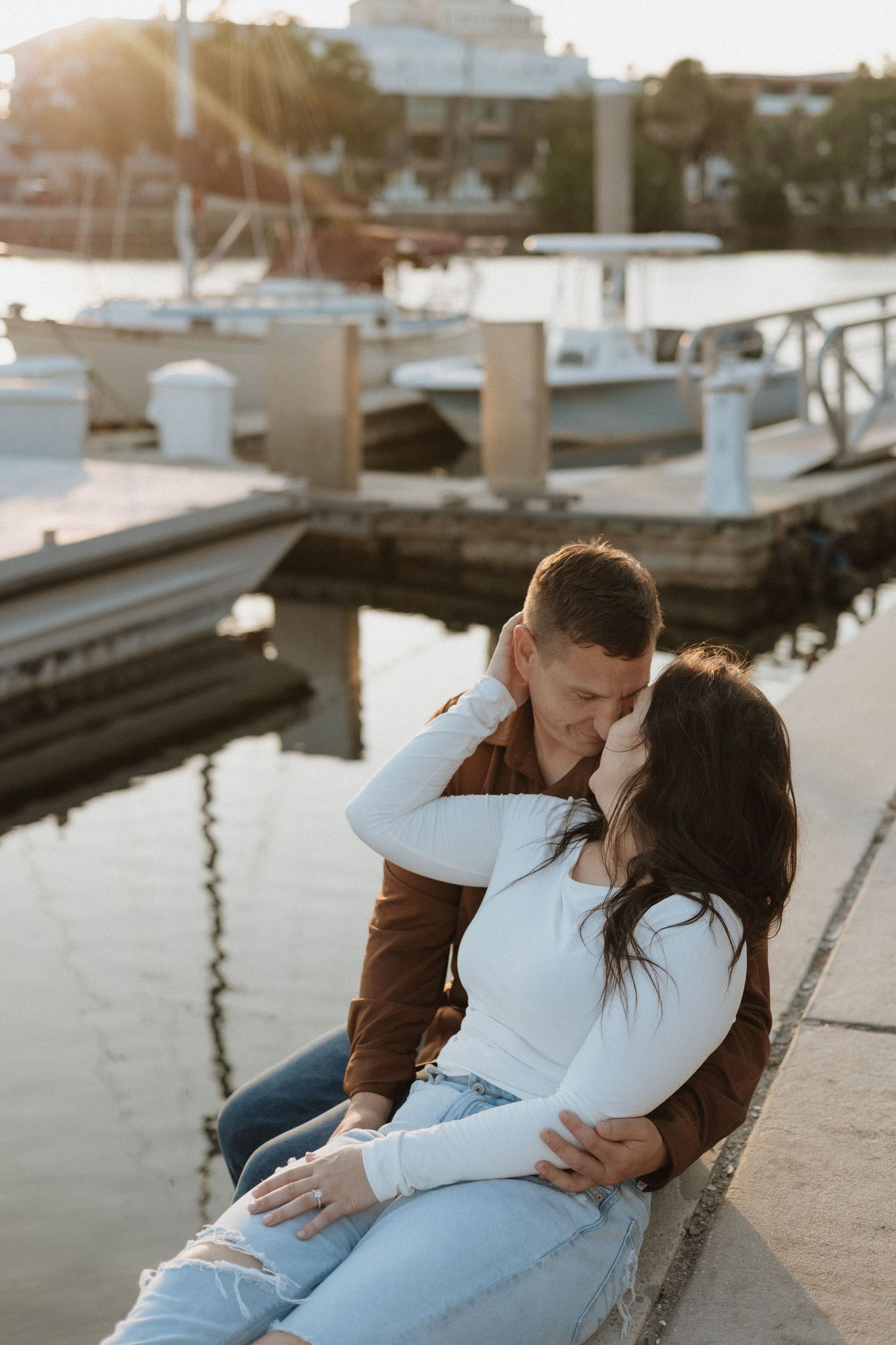Sweet romantic moment shared on a dock during sunset.
