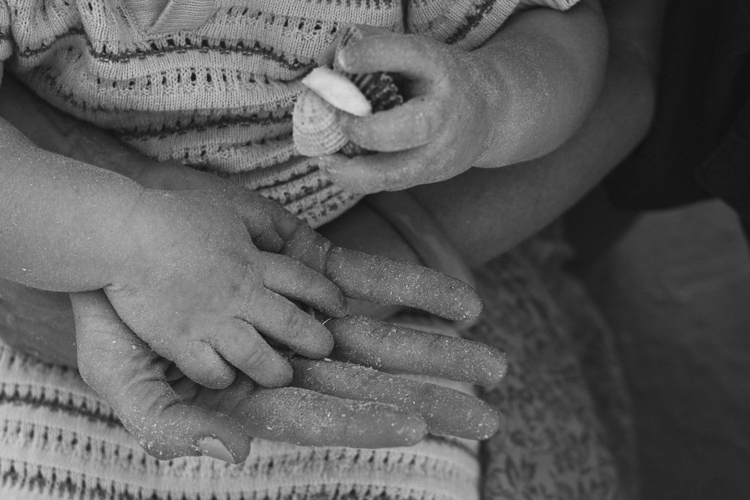 Abstract black and white composition of hands and textured material.
