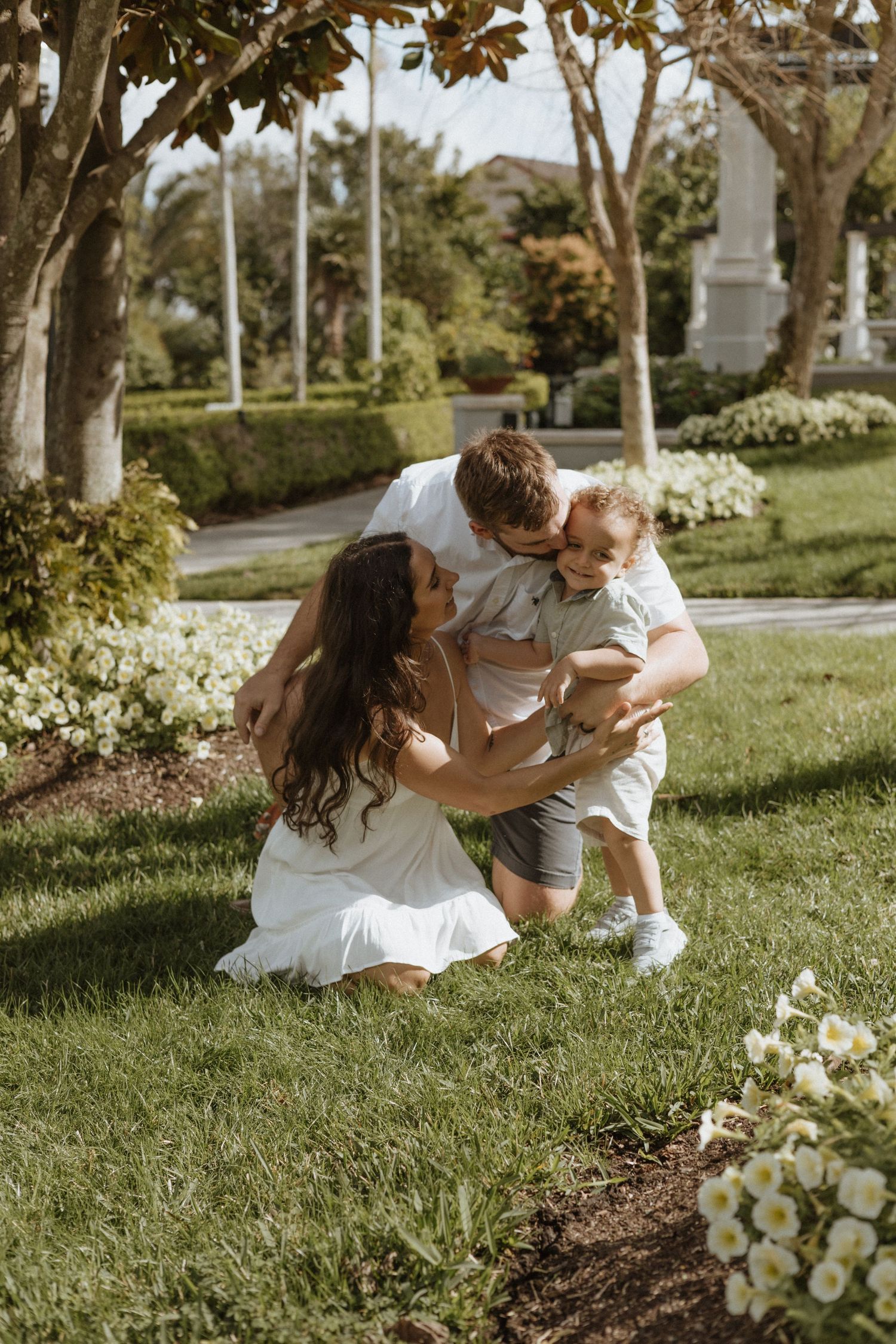 Candid moments on grass with white flowers in foreground.