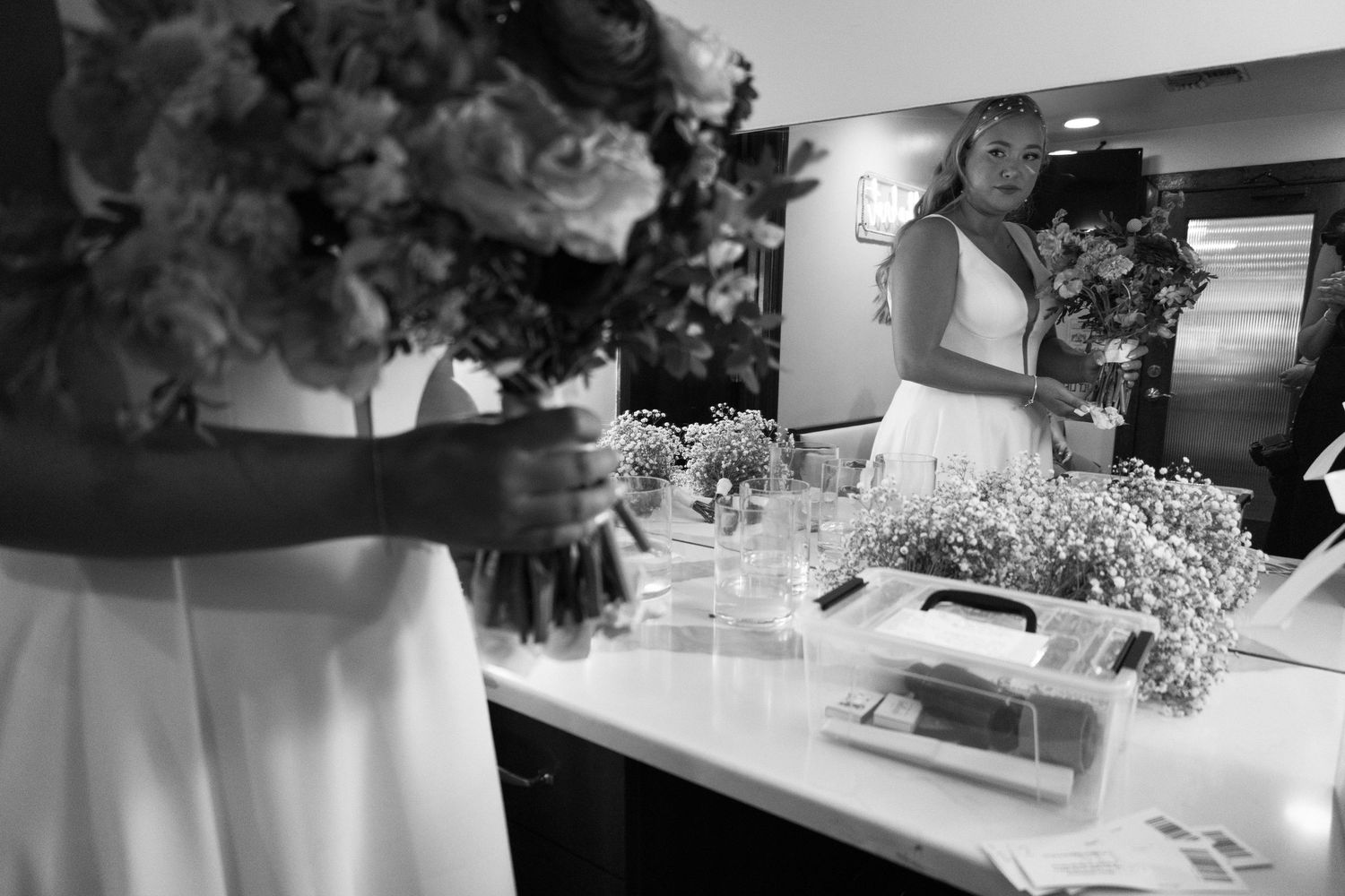 Close up detail of delicate white and pink floral arrangements with scattered petals on a table.