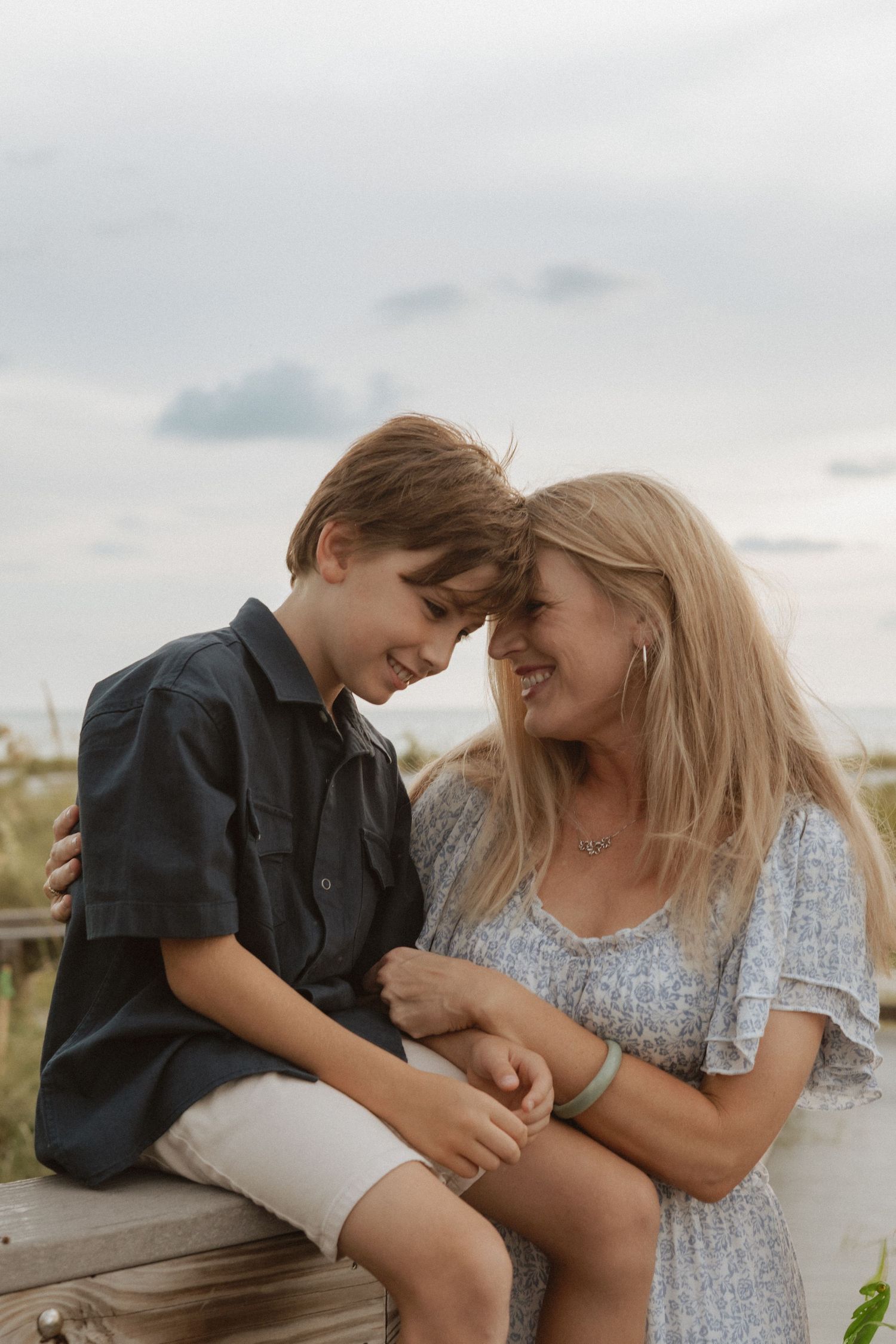 Two people sharing a tender moment in casual outfits during a portrait session.
