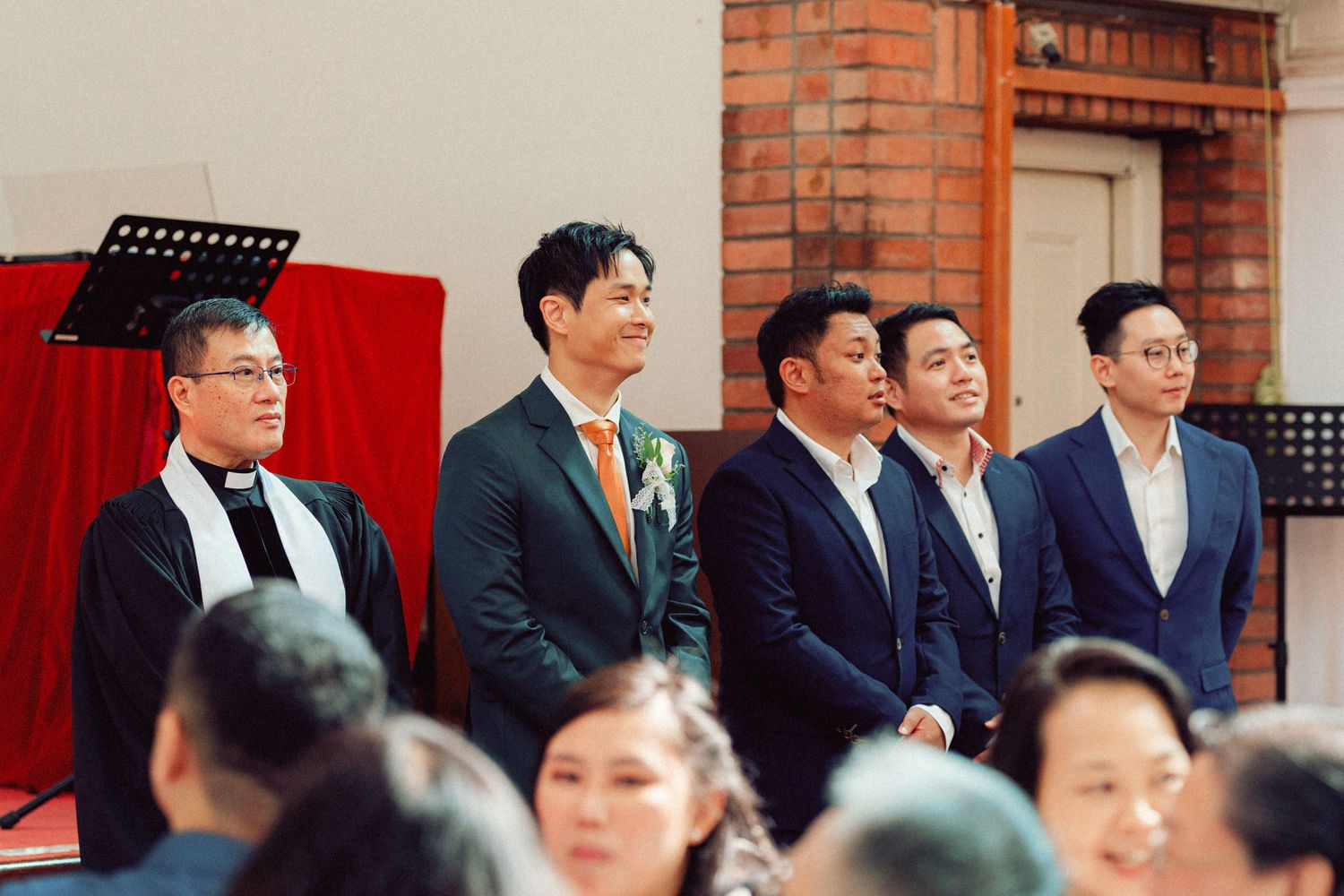 Church wedding ceremony with traditional brick interior and formal guest seating.