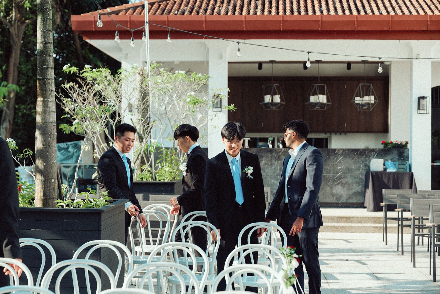 Business professionals gather in a modern office space with glass walls and traditional Asian architectural elements.
