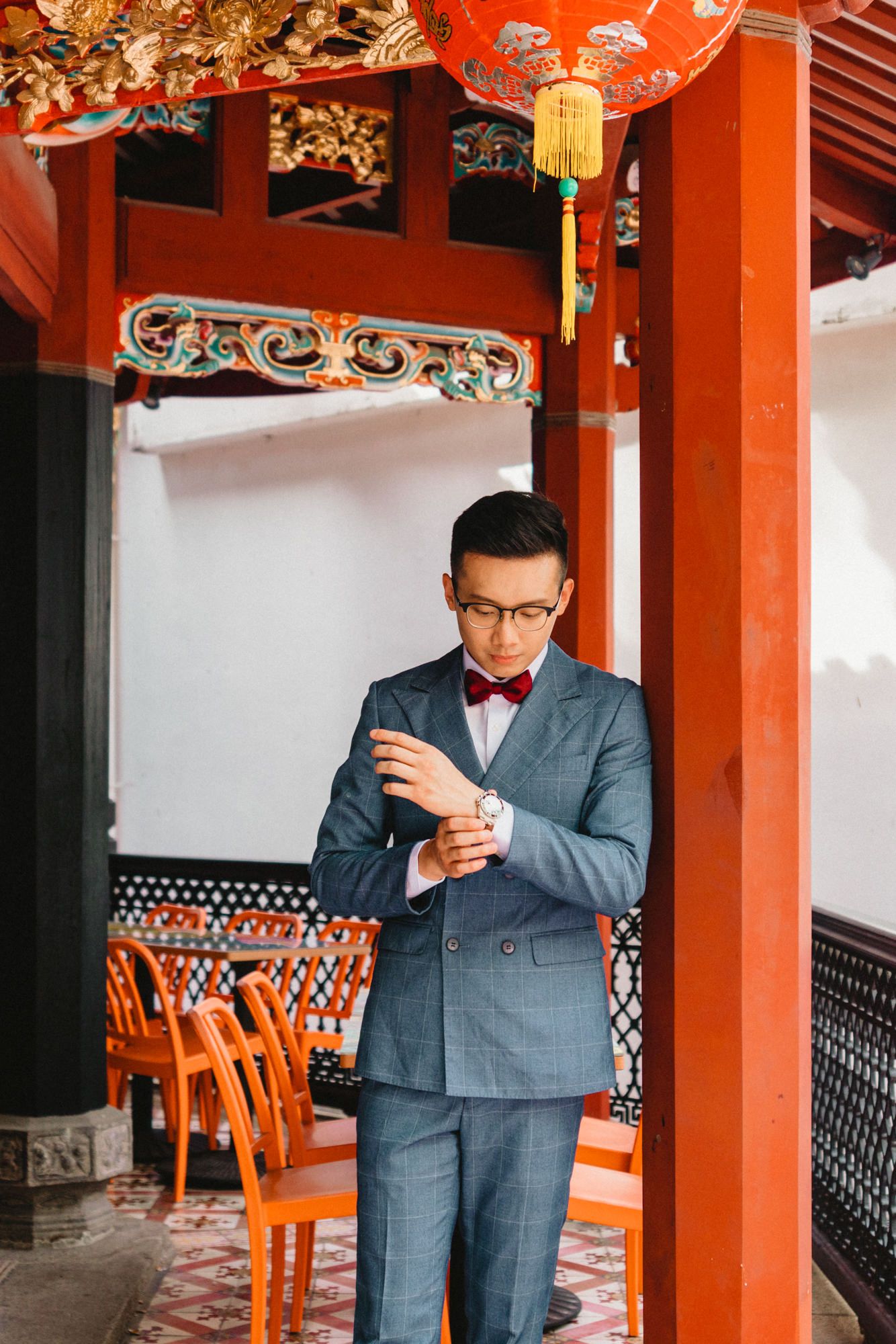 Interior of Chinese temple with red columns and traditional wooden furniture.