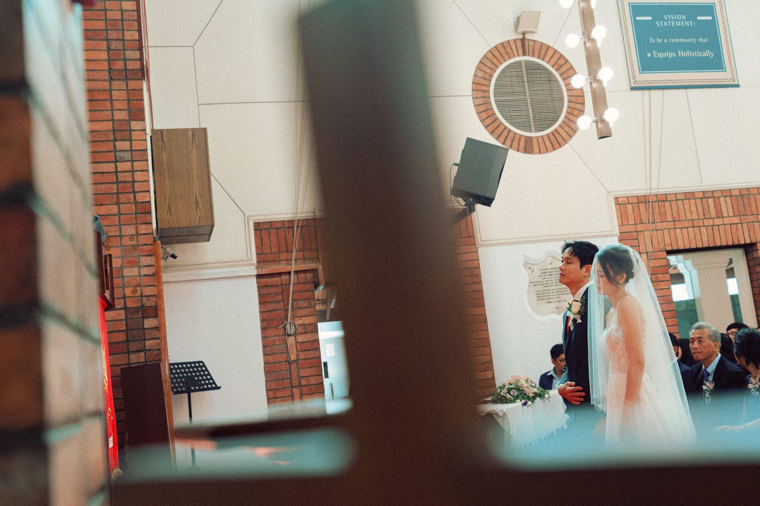 Interior architectural details of brick church with arched windows during ceremony.