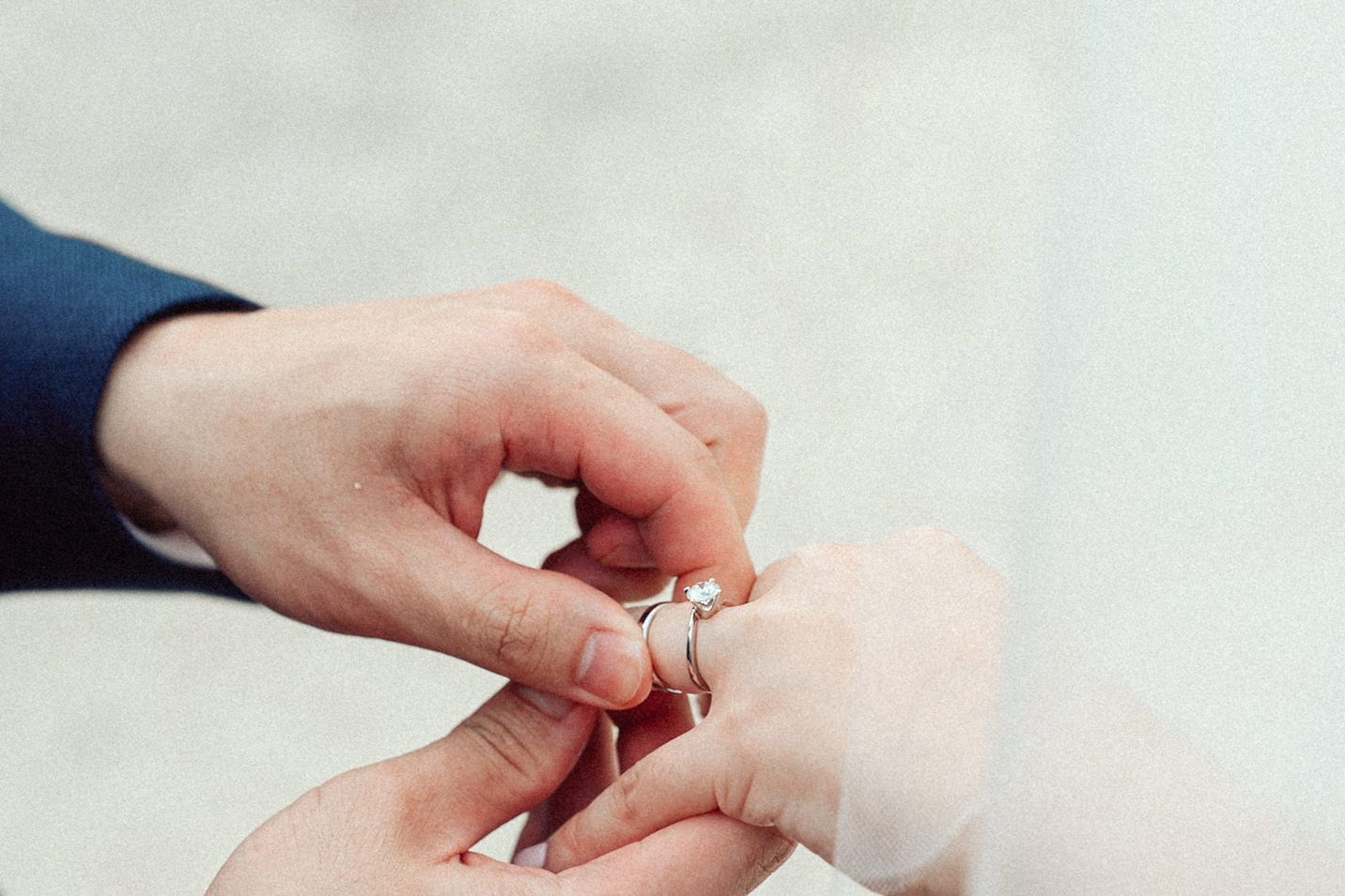 Close up of hands exchanging wedding rings during a marriage ceremony.