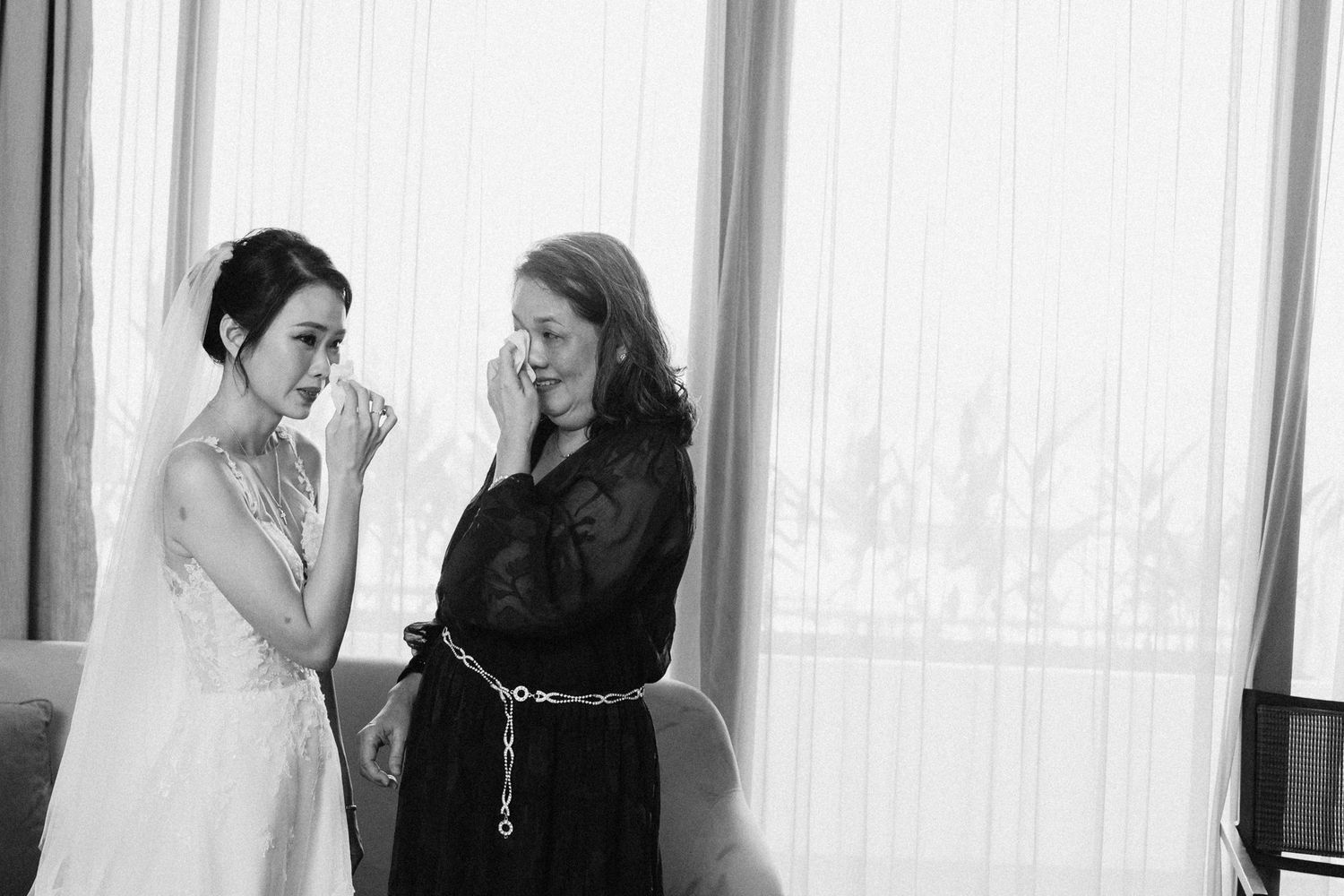Wedding preparations in a hotel room with bridesmaids in light blue dresses helping with final touches.