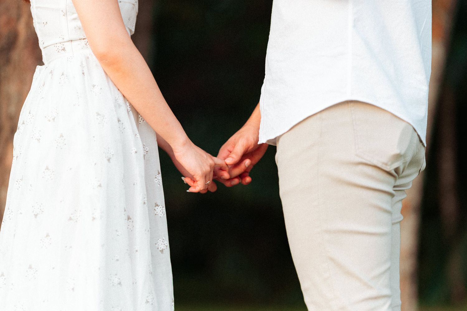Elegant white dress contrasting against casual attire in outdoor setting.