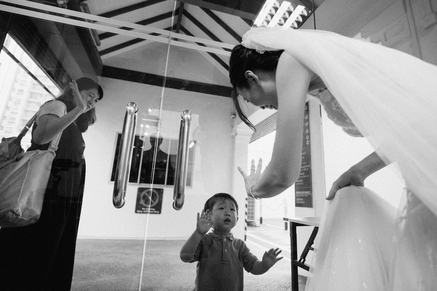 A wedding celebration moment captured in black and white with a child reaching up.