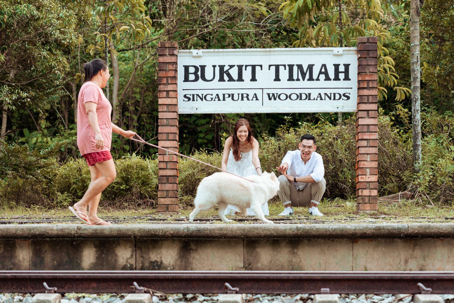 Historic railway platform with vintage signage and tropical vegetation.