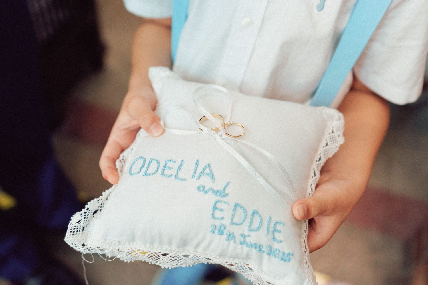 Wedding details showing light blue accents and delicate lace decorations.