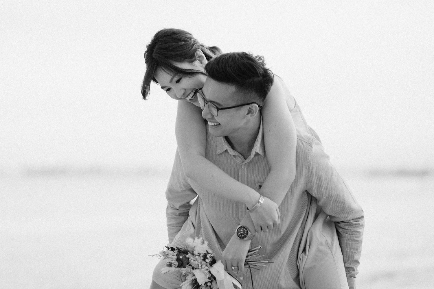 Monochrome portraits of a couple laughing and embracing in natural light.