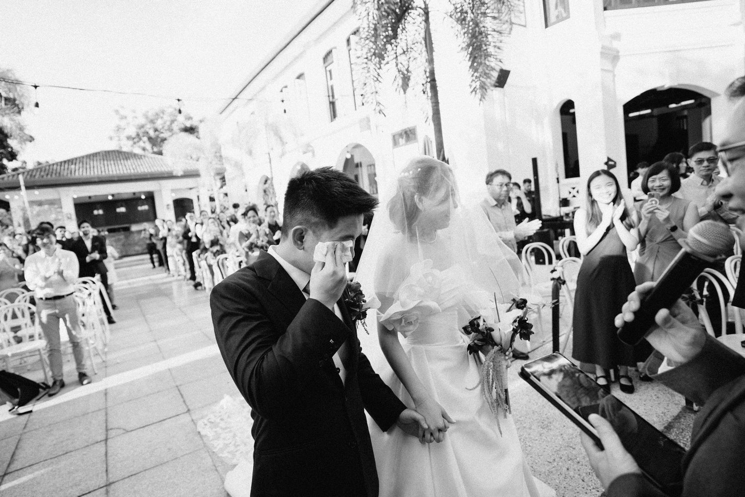 A series of black and white wedding photos showing emotional moments and celebrations during a reception.