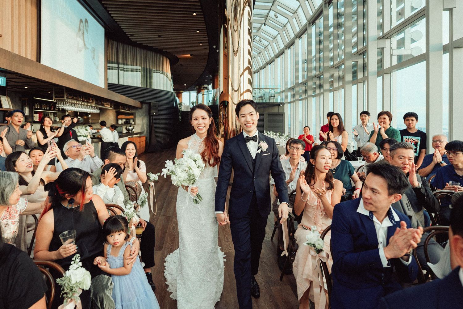 Wedding reception venue filled with celebrating guests in formal attire.