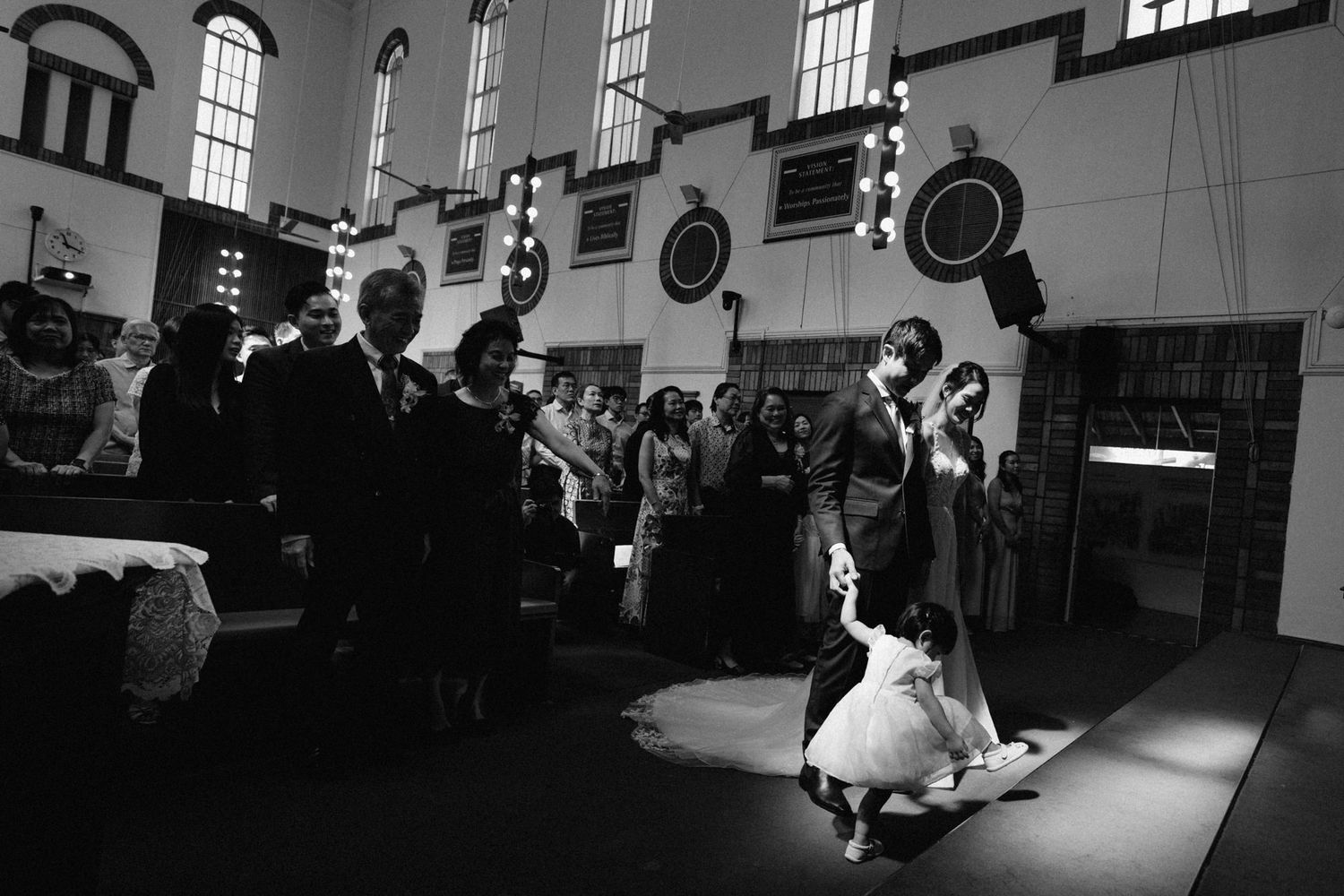 Wide angle view of church interior during wedding ceremony with dramatic lighting.