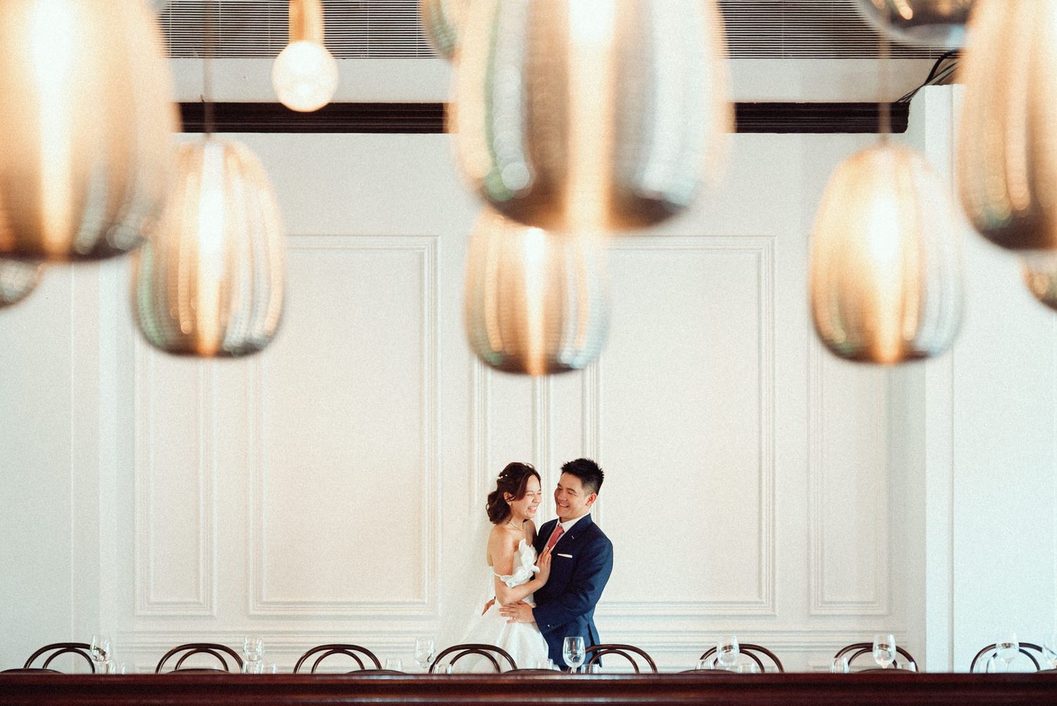 A romantic couple shares an intimate dance moment in an elegant ballroom with soft lighting and ornate decor.