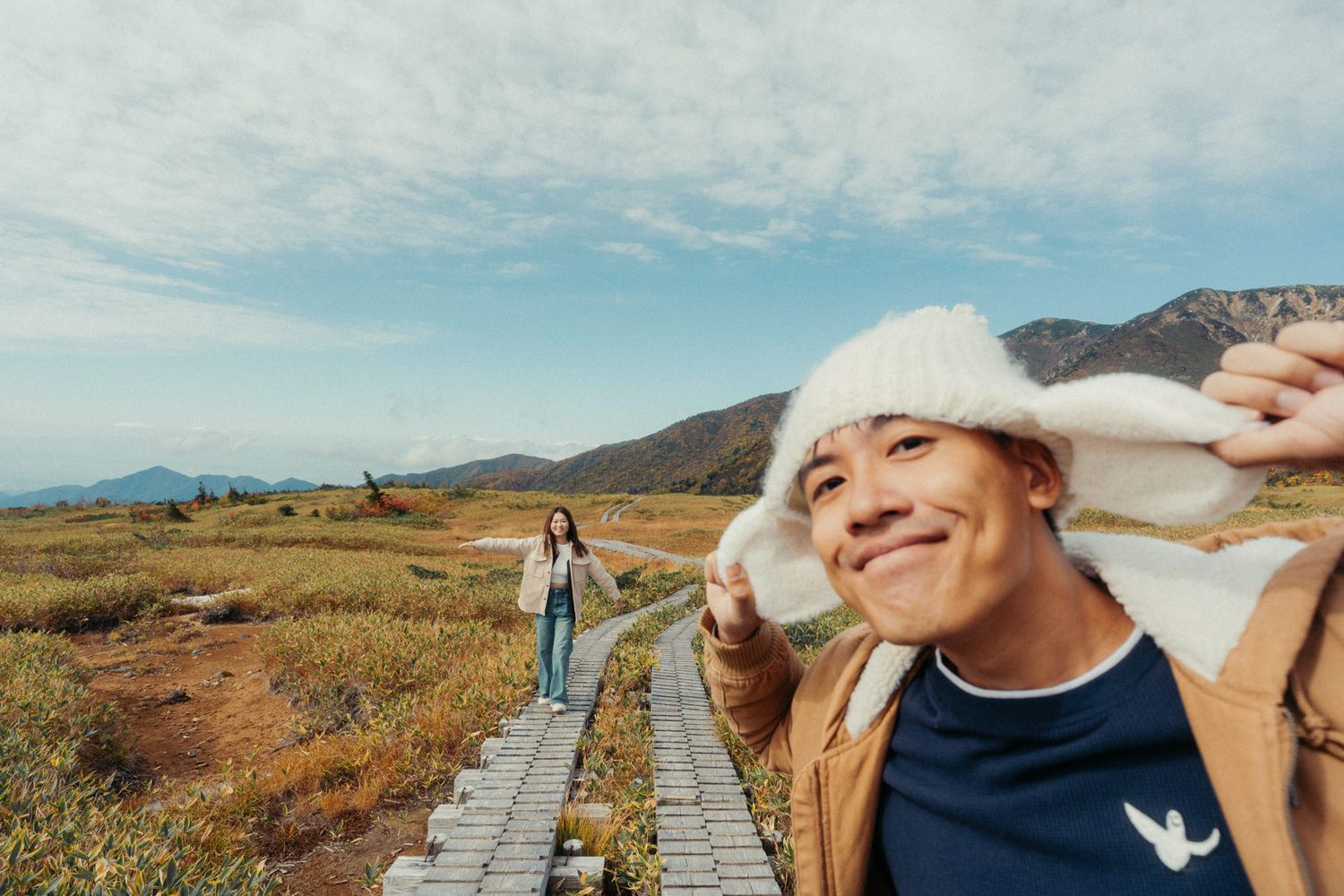 Scenic mountain boardwalk trail winding through a rugged desert landscape under blue skies.