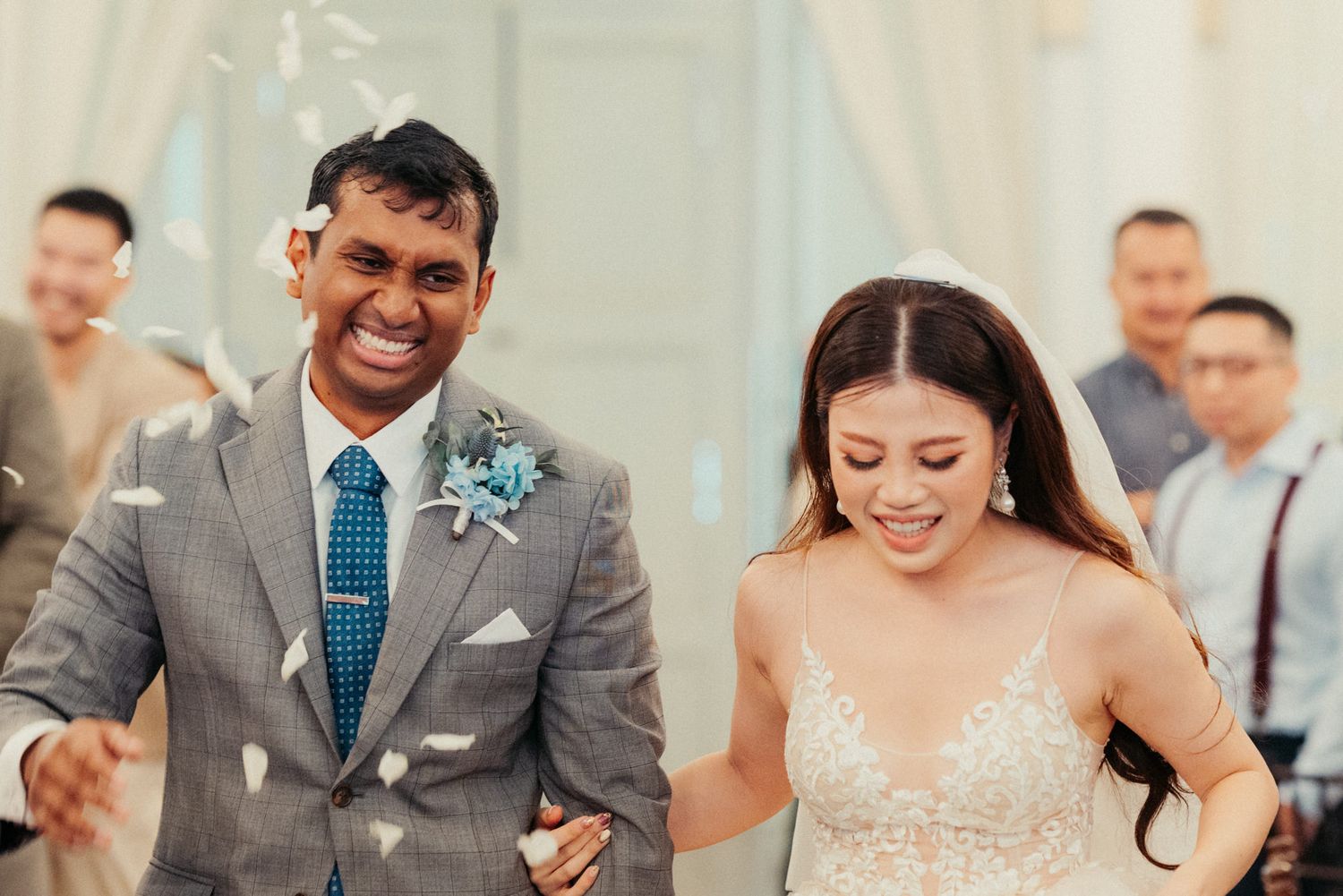 Happy bride and groom walk down the aisle as confetti falls during their elegant wedding ceremony.
