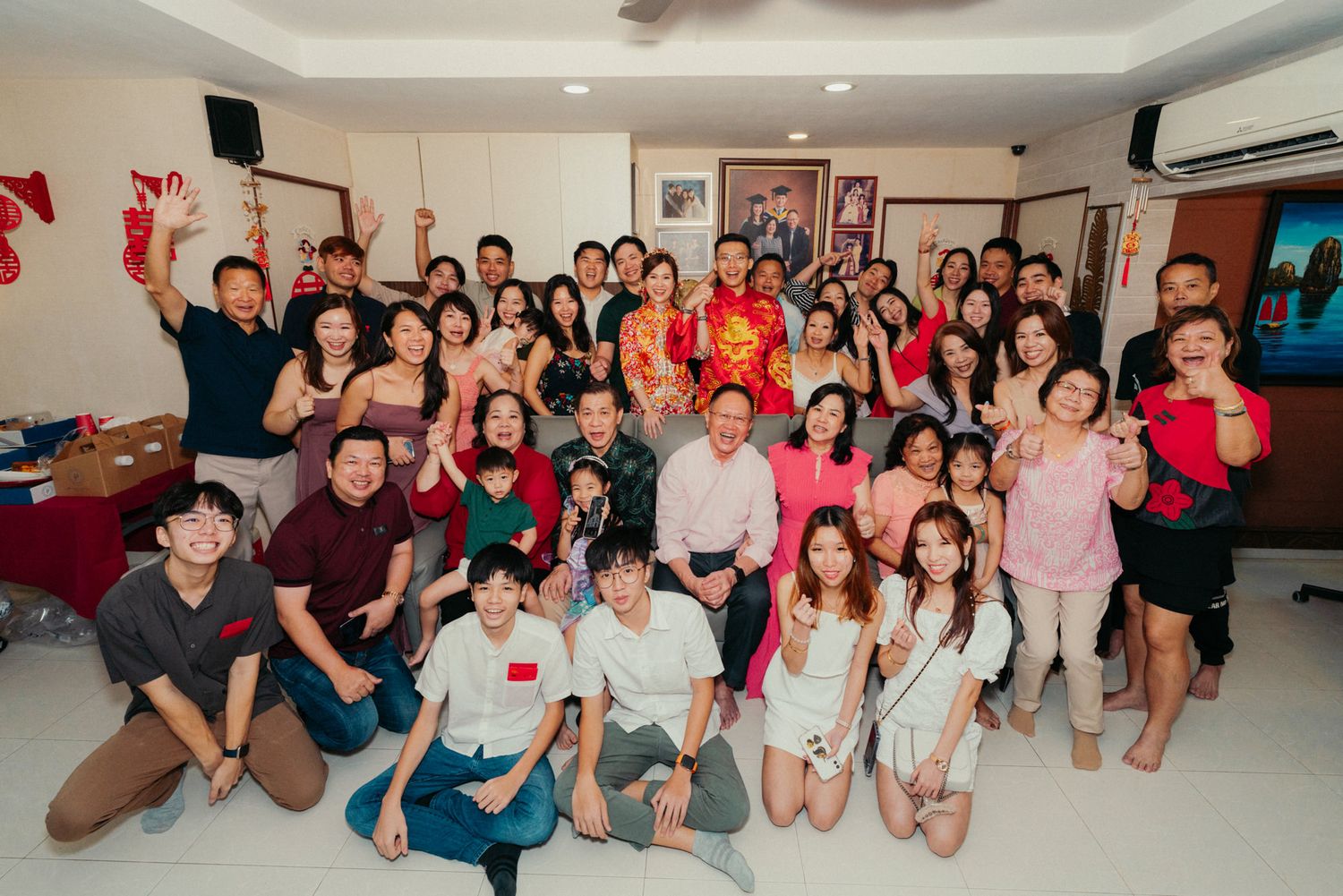 Large group of smiling people posing together at a festive indoor gathering, celebrating a special occasion.