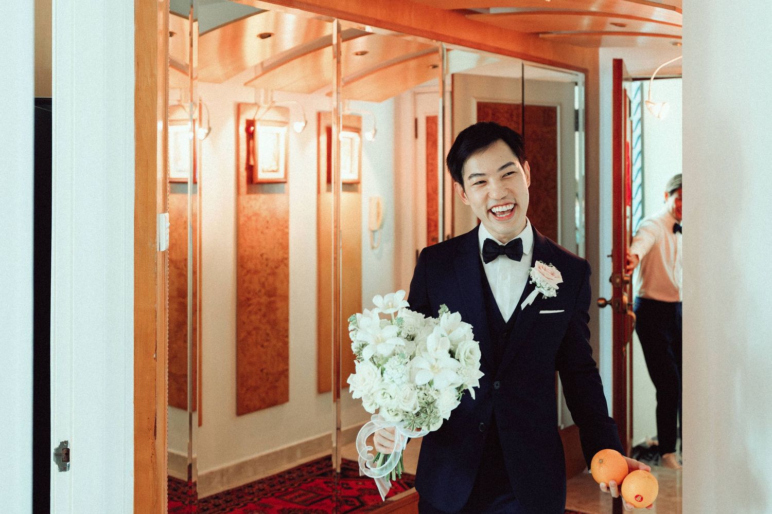 Elegant wedding ceremony setup in a hallway with white floral arrangements and warm lighting.