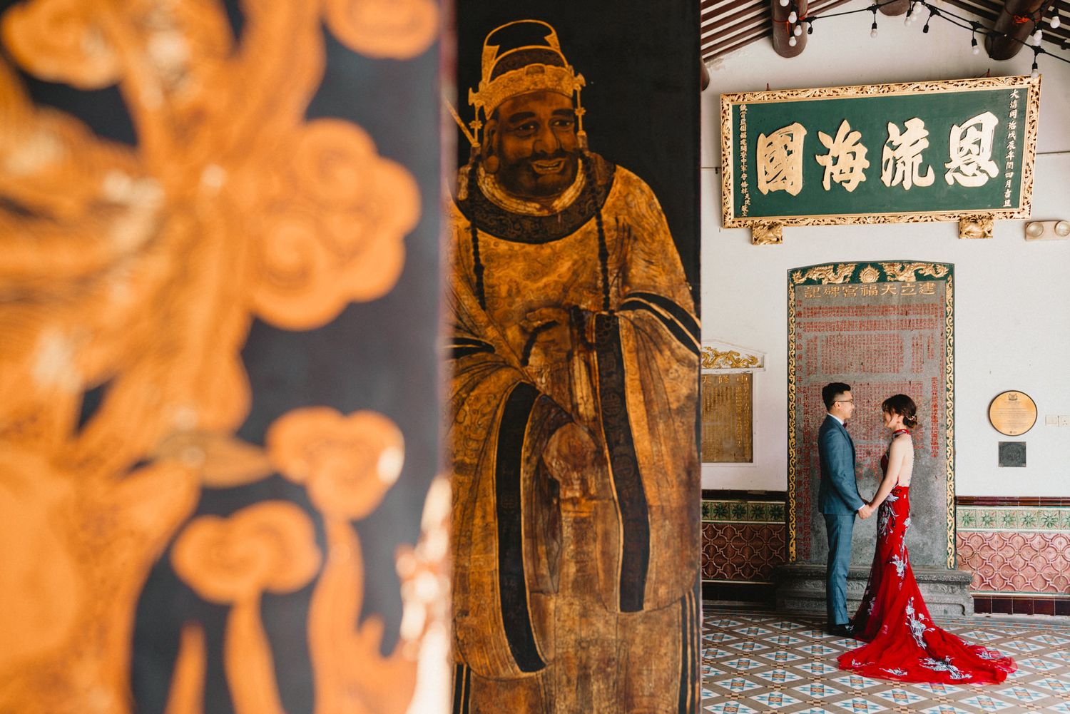 Traditional Chinese temple interior with ornate orange decorations and cultural artifacts.