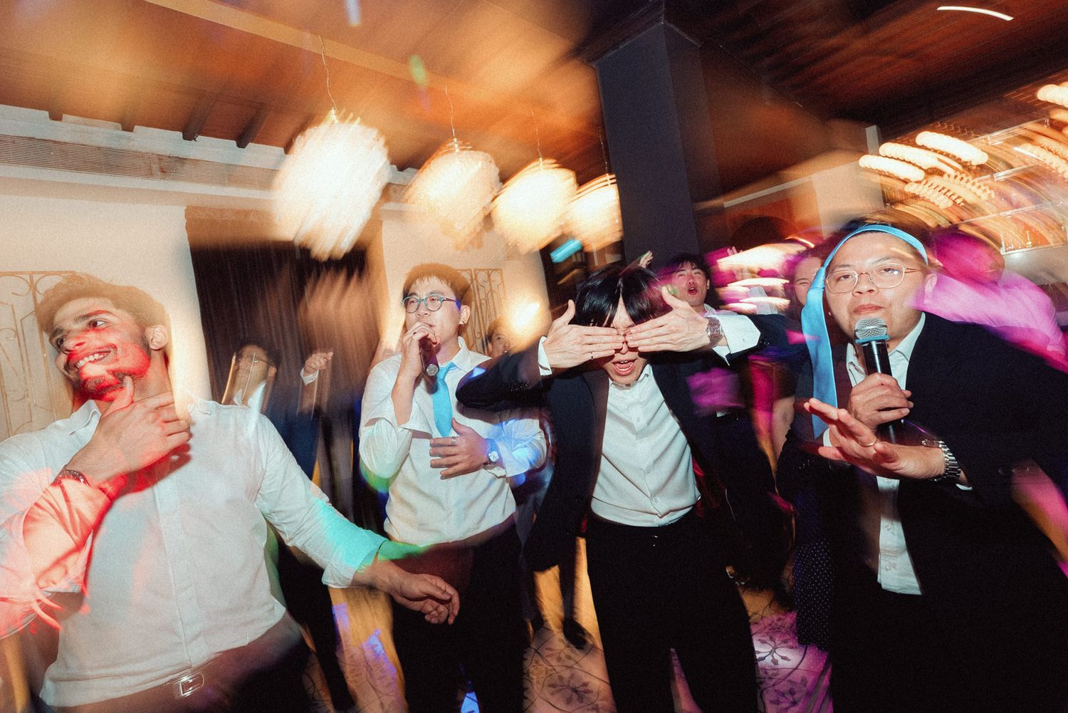 Blurred motion shots of people dancing and moving energetically at a party or nightclub event.