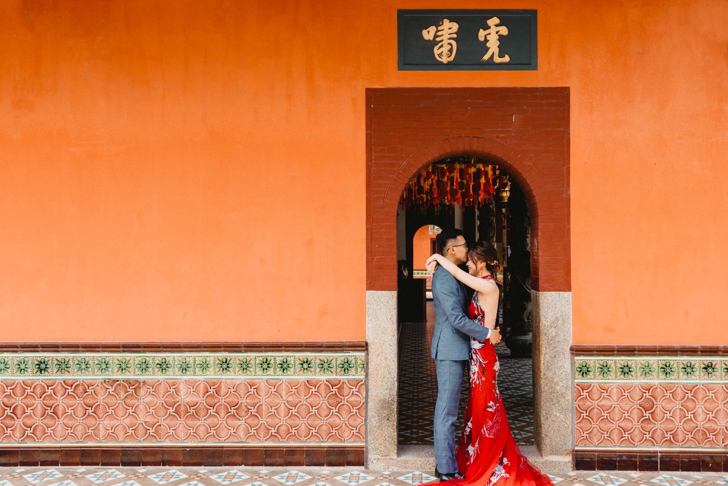 Long orange wall with traditional Chinese architectural elements and decorative patterns.