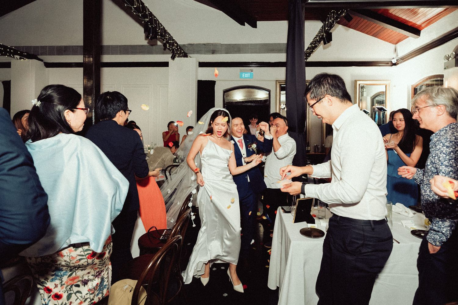 People dancing and socializing at what appears to be a lively wedding reception or party celebration.