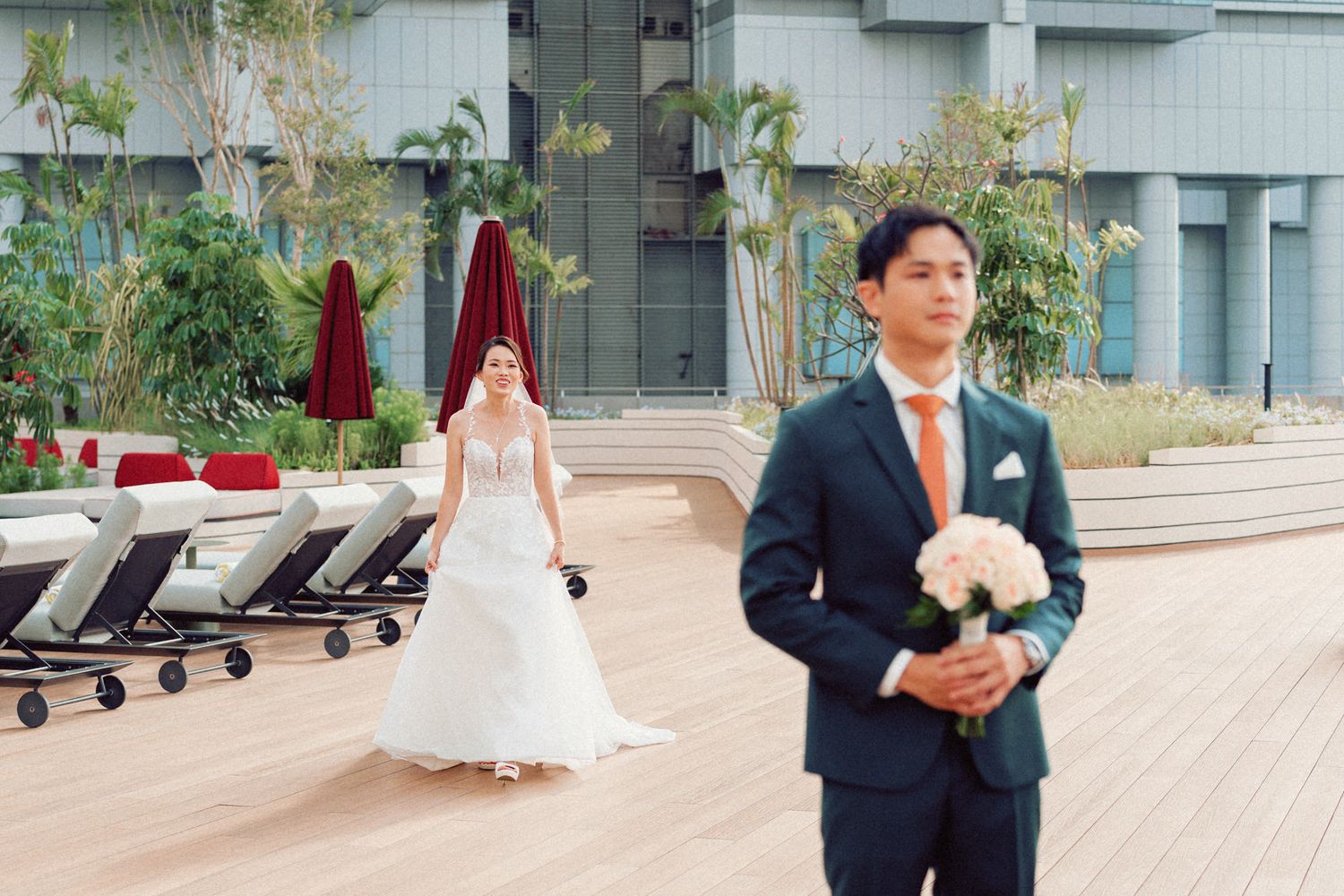 Outdoor wedding ceremony setup with decorative plants and chairs on a modern terrace.