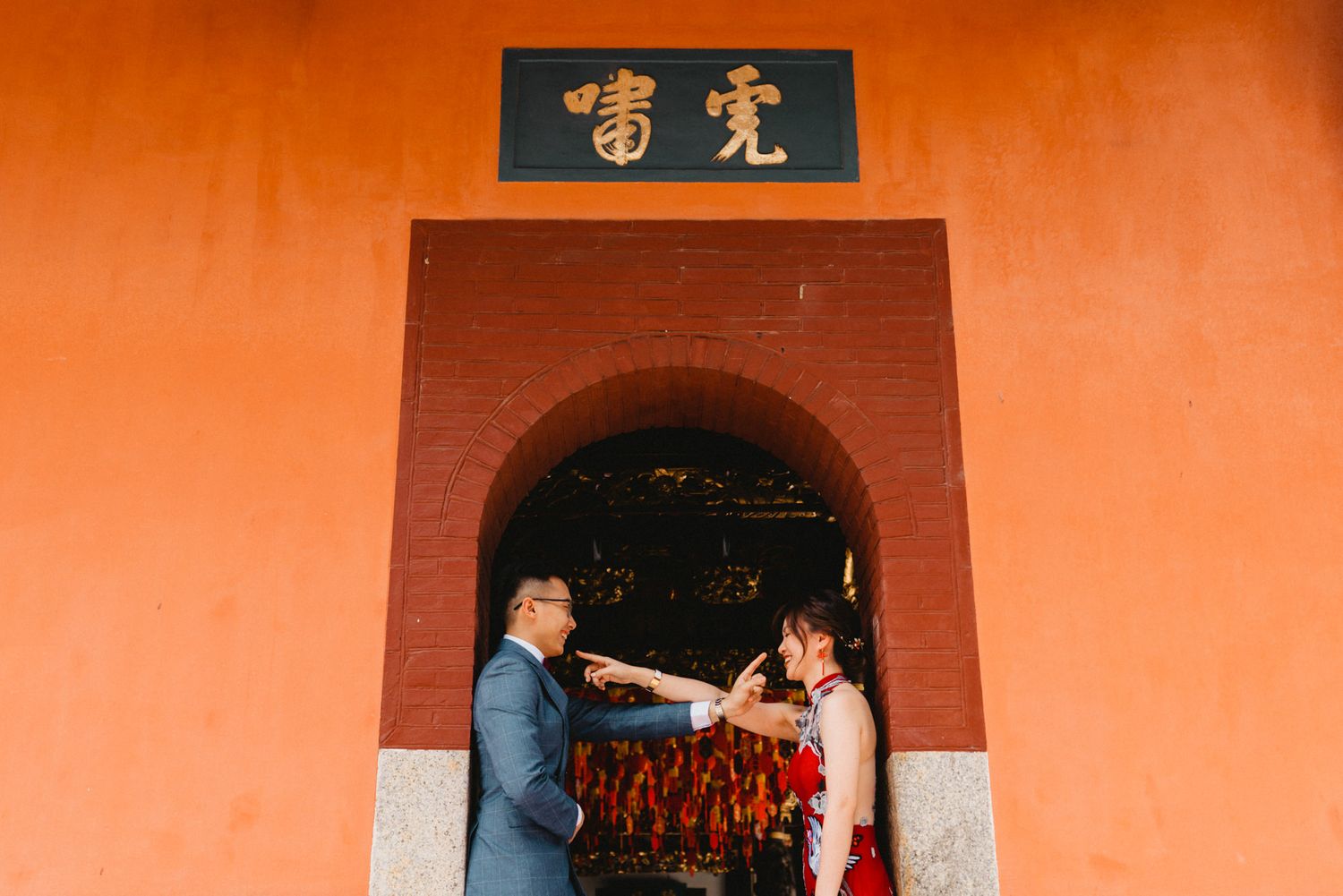 Orange wall with Chinese calligraphy signs and traditional architectural details.