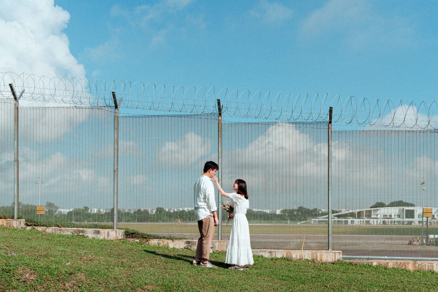 A series of five photos showing people walking along a fence line in a grassy field on a sunny day.