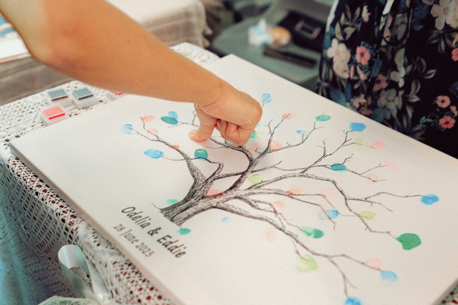 Fingerprint tree guest book with colorful thumbprints forming leaves on branches.