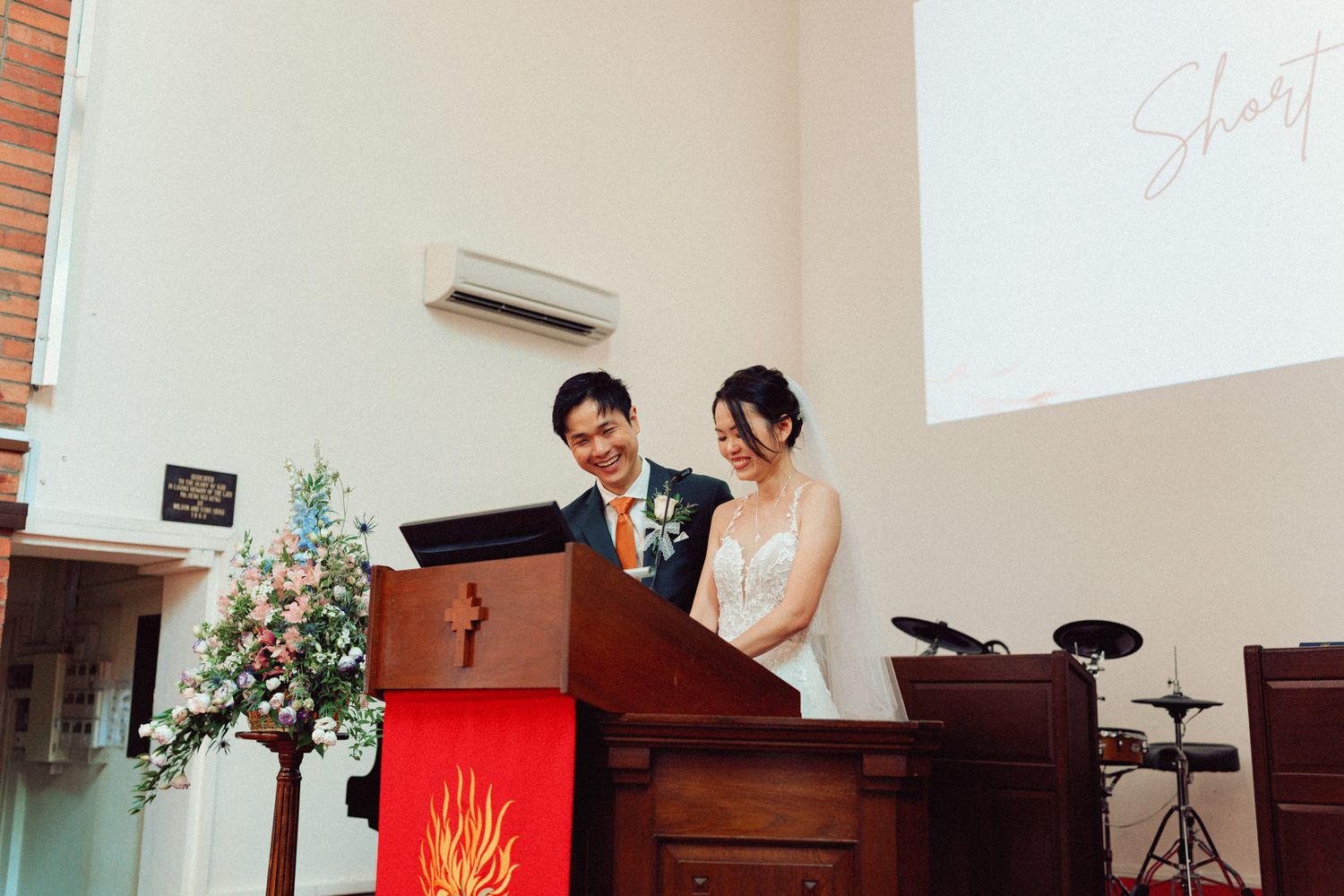 Church sanctuary decorated for wedding ceremony with brick walls and white accents.