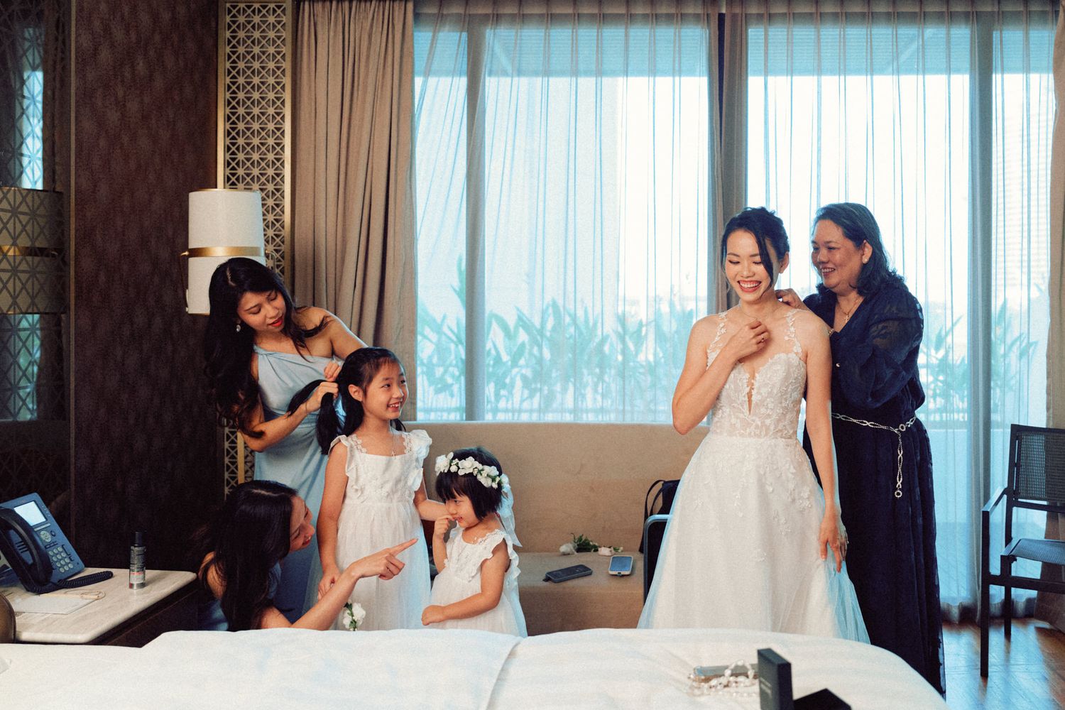 Getting ready moments captured in a luxurious hotel suite with city views.