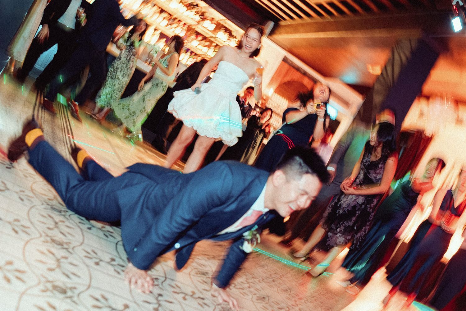 People dancing and having fun at a lively party with warm lighting and blurred motion effects.