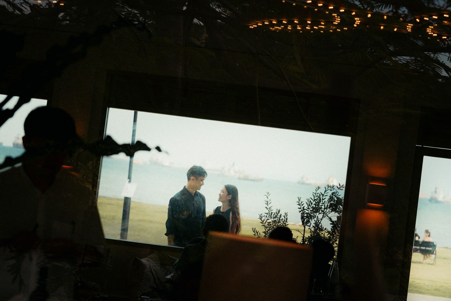 Silhouetted cityscape at dusk with twinkling lights in the distance.