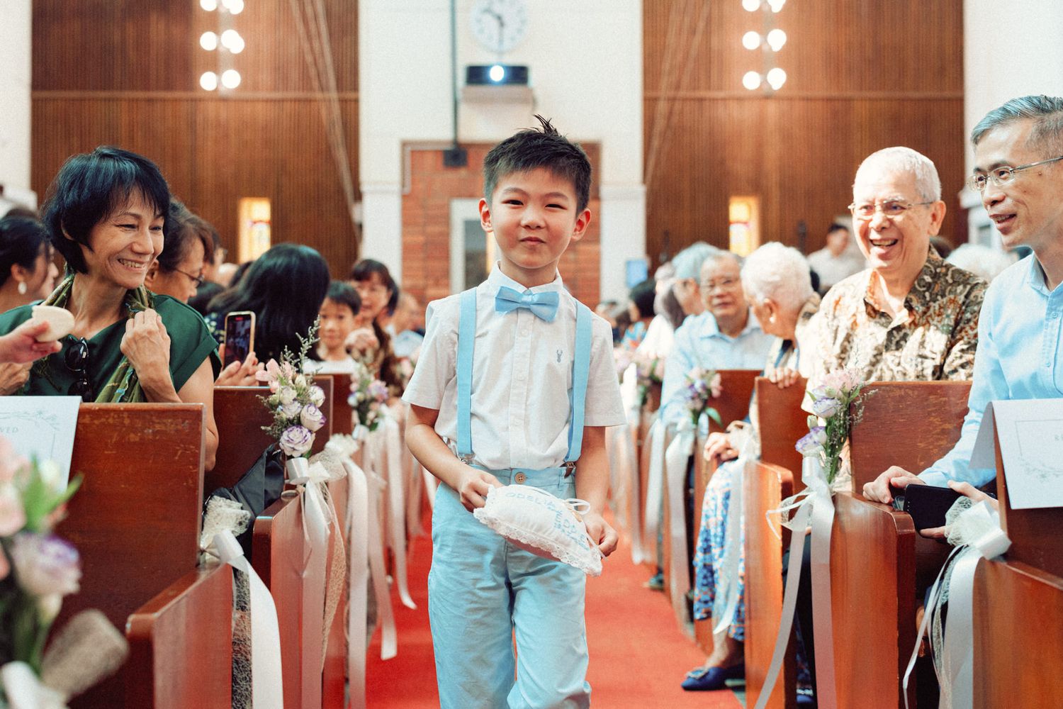 Wedding ceremony in a church with wooden paneling and warm lighting.