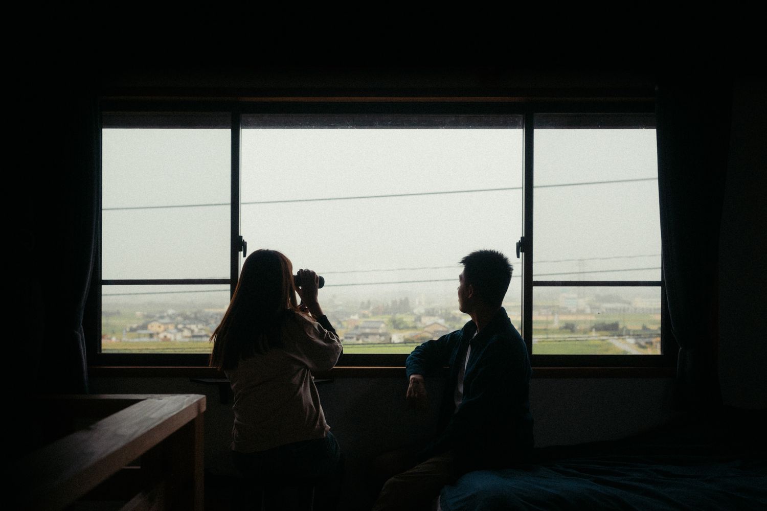 Silhouettes visible through windows create a moody atmospheric scene.