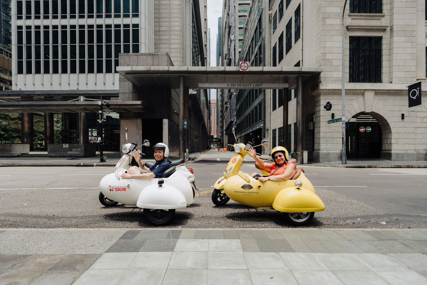 A series of vintage vehicles including a yellow submarine-shaped car parked on a city street.