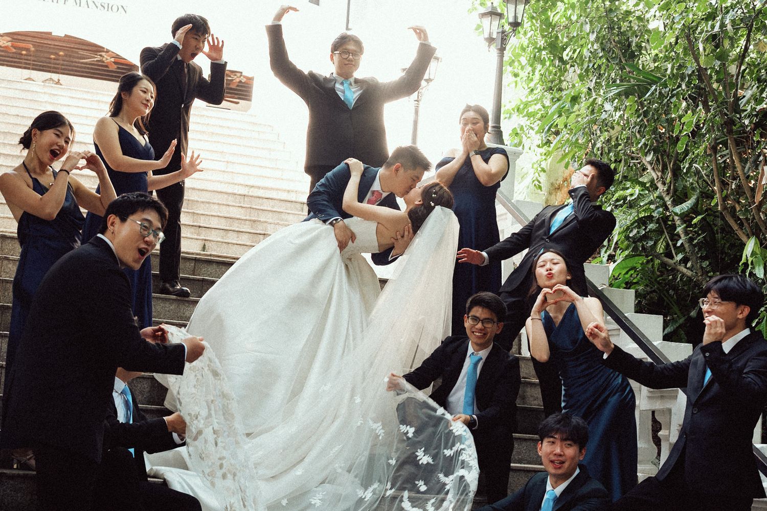 A group of wedding guests dance and celebrate with the bride in her white gown during a joyous reception.