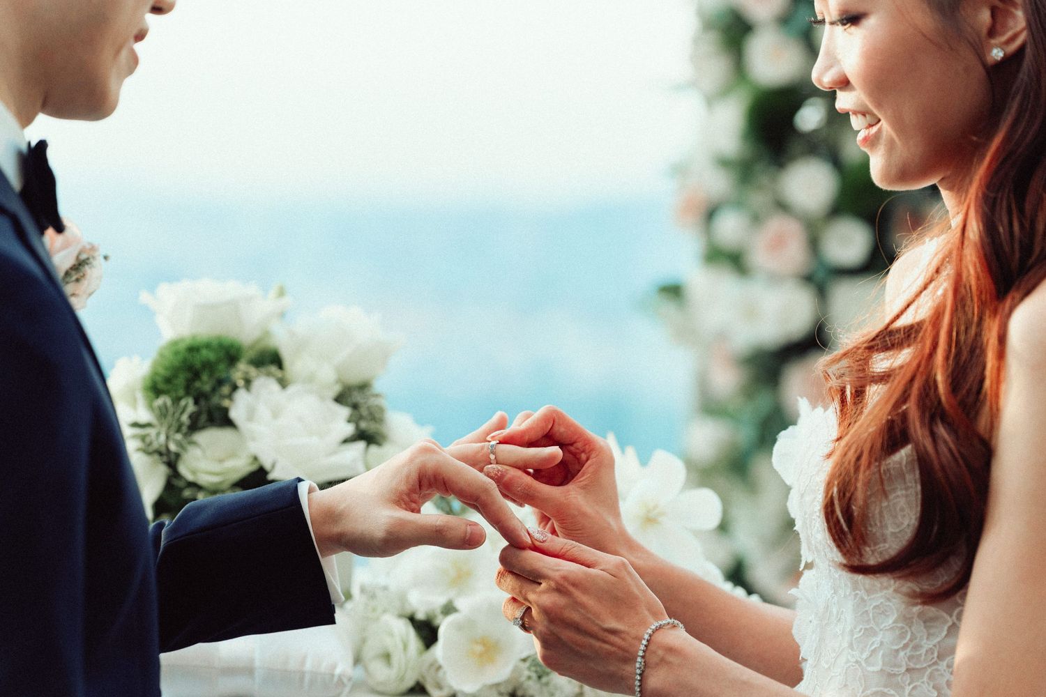 Close-up of a couple exchanging rings during an elegant wedding ceremony.