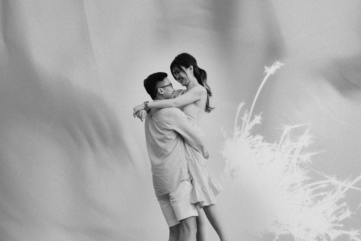 Black and white photo series of a couple sharing intimate moments outdoors.