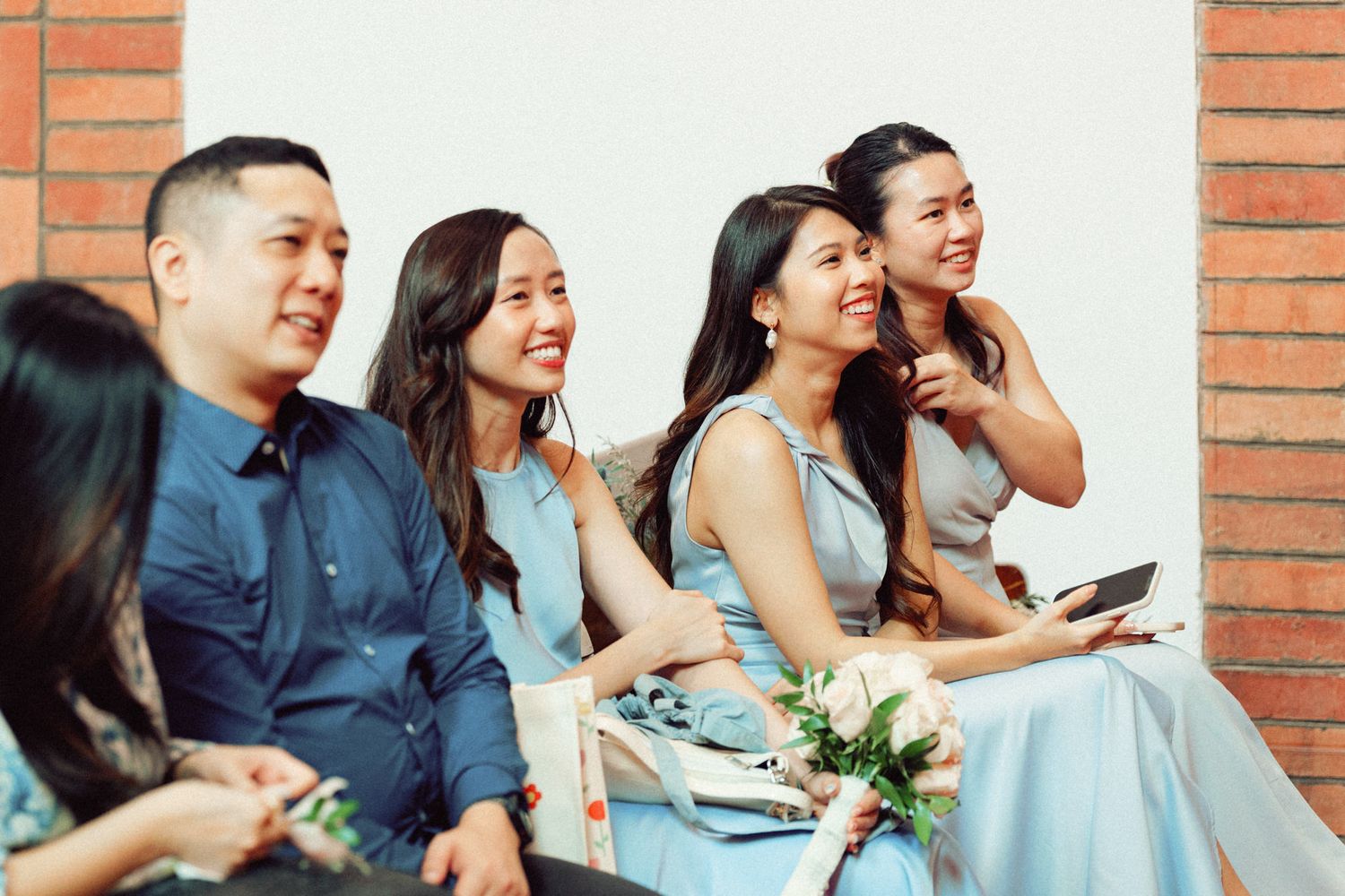 Wedding guests seated in church pews sharing joyful moments during ceremony.