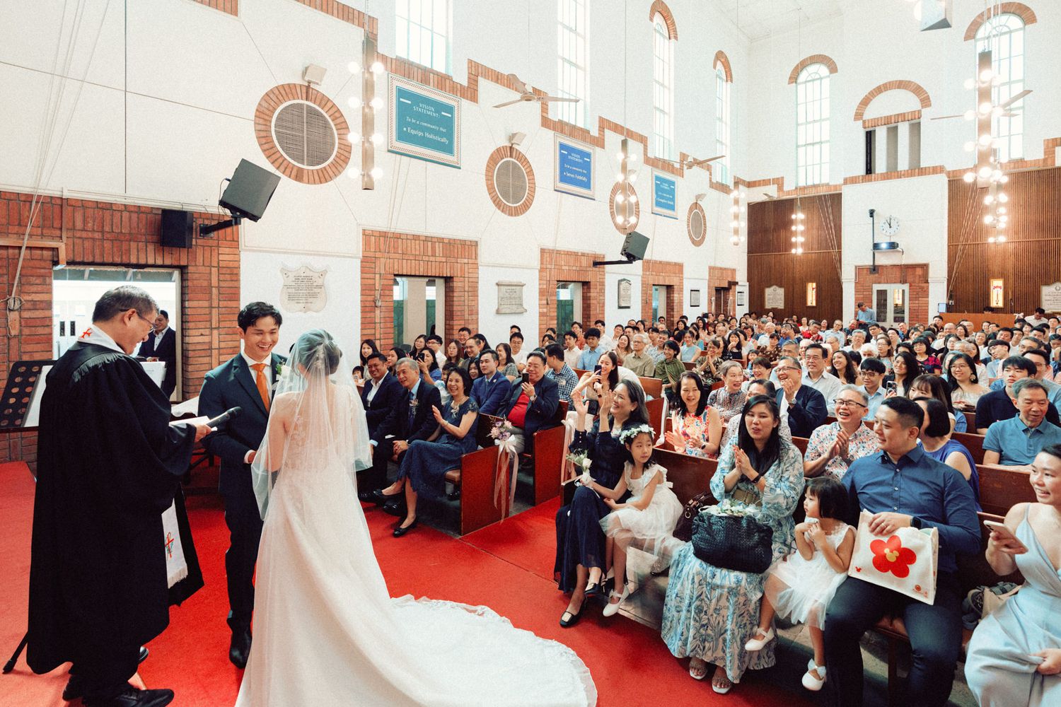 Wide view of church sanctuary filled with wedding guests during ceremony.