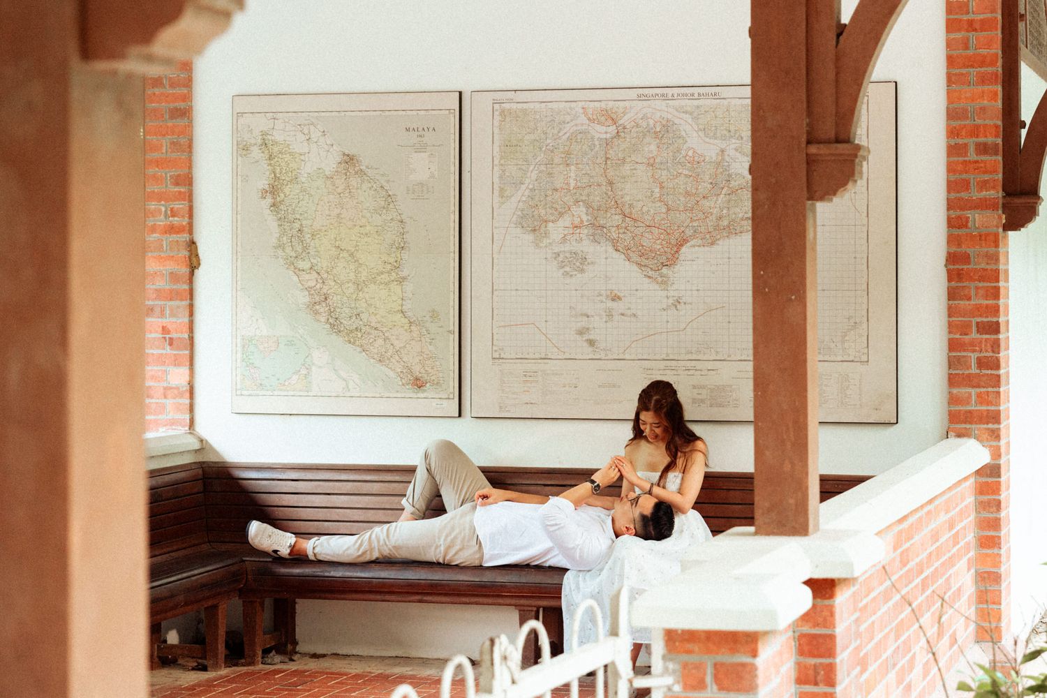 Interior space with brick columns and maps displayed on white walls.
